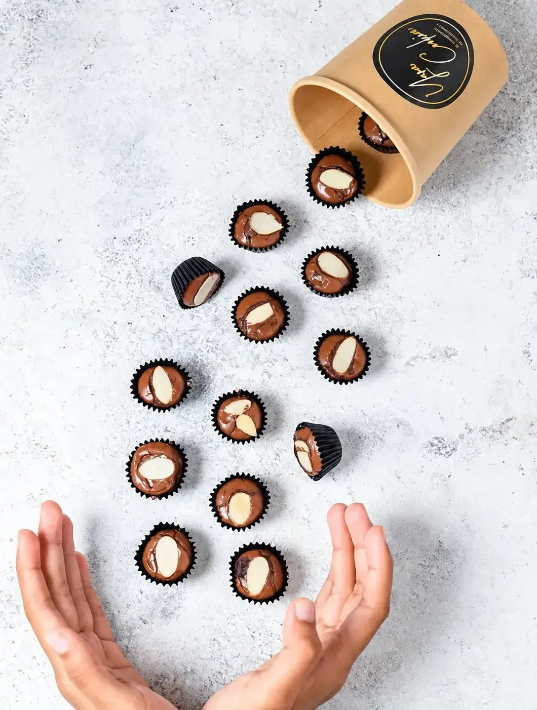Hands pouring Yara Cookies almond cookie cups